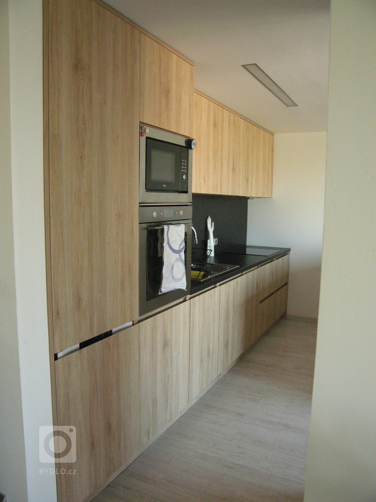 Dle návrhu architekta bylo vytvořeno zkosení na horní hraně dvířek, které vytvořilo prostor pro uchycení.
