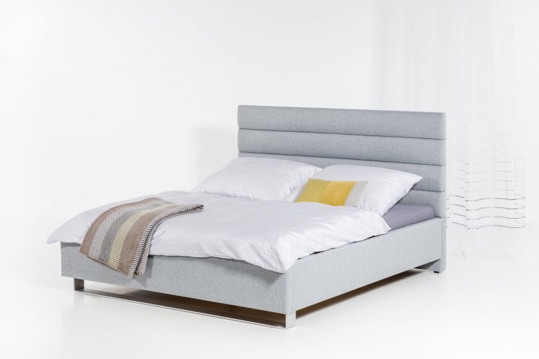 Čalouněná postel s čelem tvořeným z jednoduchých zaoblených pruhů.

- stabilní pevná konstrukce
- pohodlná výška pro vstávání 45 cm
- nastavení úrovně…