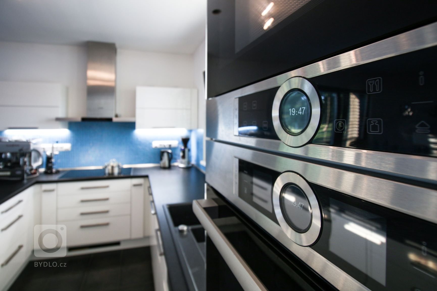 Čistá prostorná kuchyně praktického tvaru U v moderní bílo-černo-modré kombinaci. Požadavkem byla velká pracovní plocha, místo na kávovar a barové sezení. Vše…