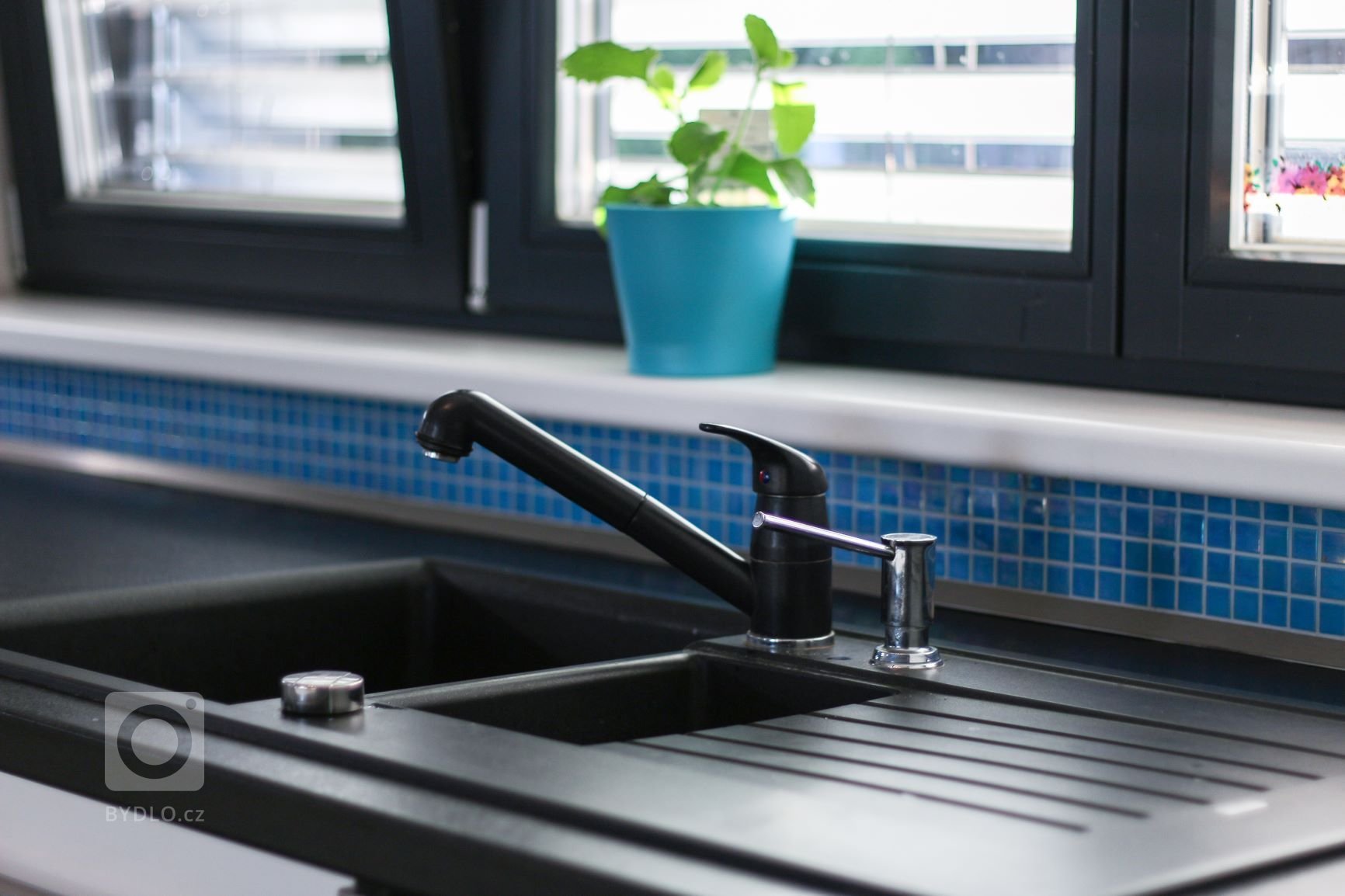 Čistá prostorná kuchyně praktického tvaru U v moderní bílo-černo-modré kombinaci. Požadavkem byla velká pracovní plocha, místo na kávovar a barové sezení. Vše…