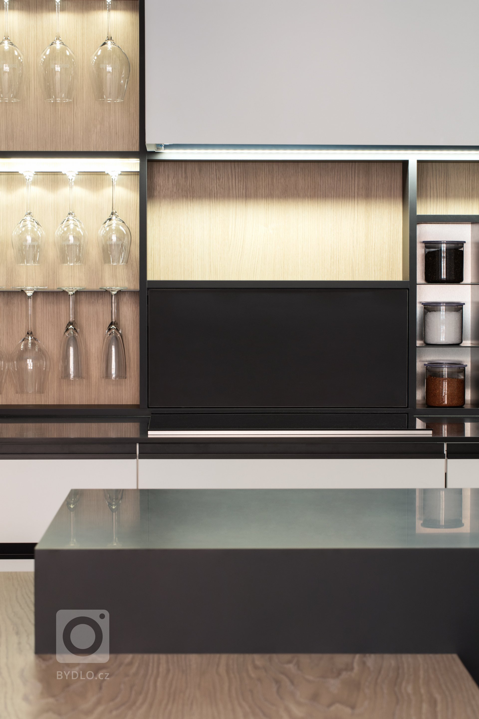 Moderní kuchyně citlivě korespondující s bytem v historickém domě v Královských Vinohradech. Použity byly materiály jako: černý Corian, bělená dubová dýha.…