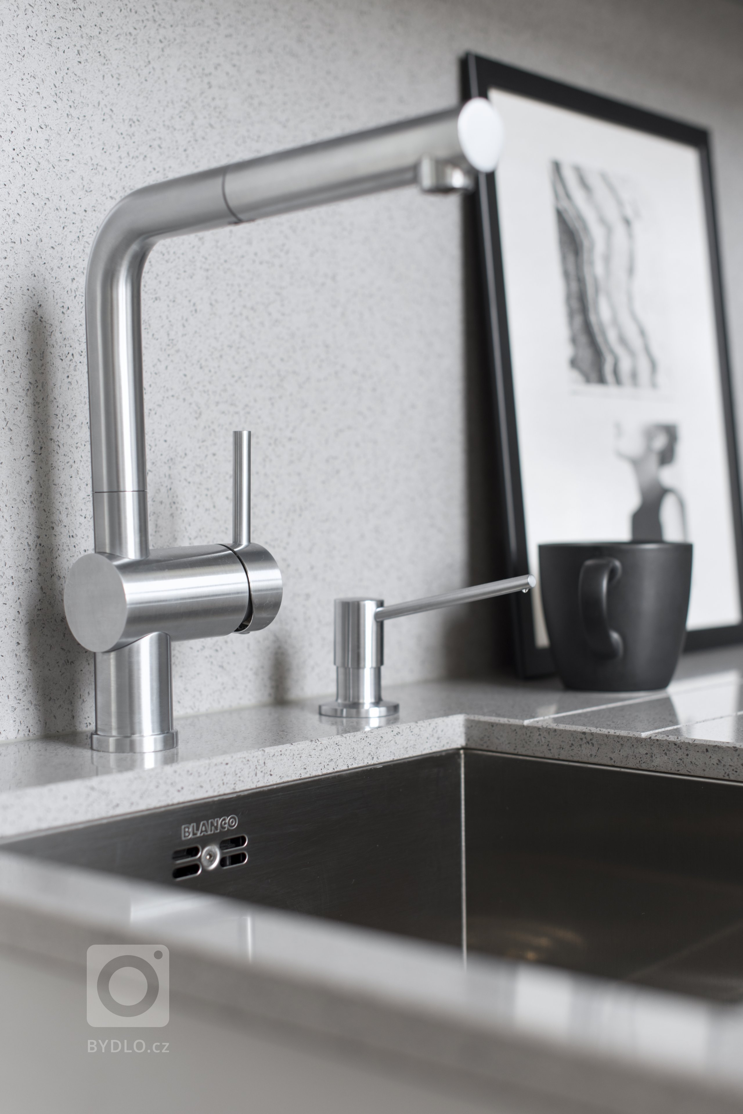 Kromě toho, že je umělý kámen velice kvalitní a odolný materiál, má jednu velkou výhodu! A to je možnost upevnění zápustného dřezu pod pracovní desku.
Při úklidu pracovní plochy setřete veškeré nečistoty rovnou do dřezu. Nedochází tak v místě, kde je dřez napojený na pracovní desku k usazování nečistot, plísní a bakterií, jako je tomu u klasických dřezů s horní montáží.
Další výhodou jsou vyfrézované drážky se spádem do dřezu. Ty vám nahradí odkapovou část dřezu, bez ztráty pracovní plochy. Což oceníte hlavně u malých kuchyní, jako je tato.