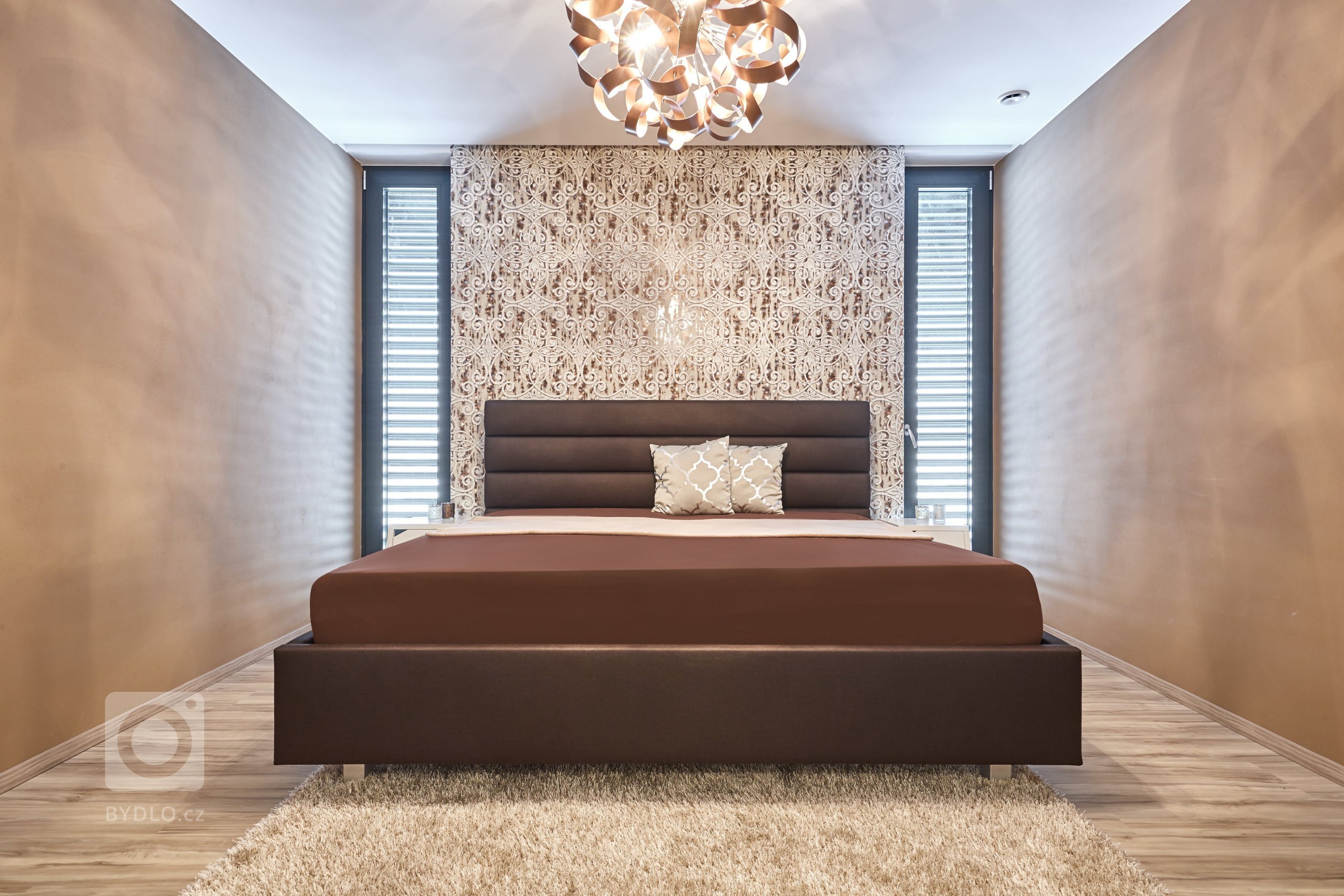 Luxusní 3D tapeta a závěsný lustr s kovových efektem tvoří dominanty této místnosti. Pro harmonii a odpočinek může být interiér doplněn o mandalu v podobě kulatého koberečku, nebo naopak pro zachování jednoduchosti, bílý koberec.