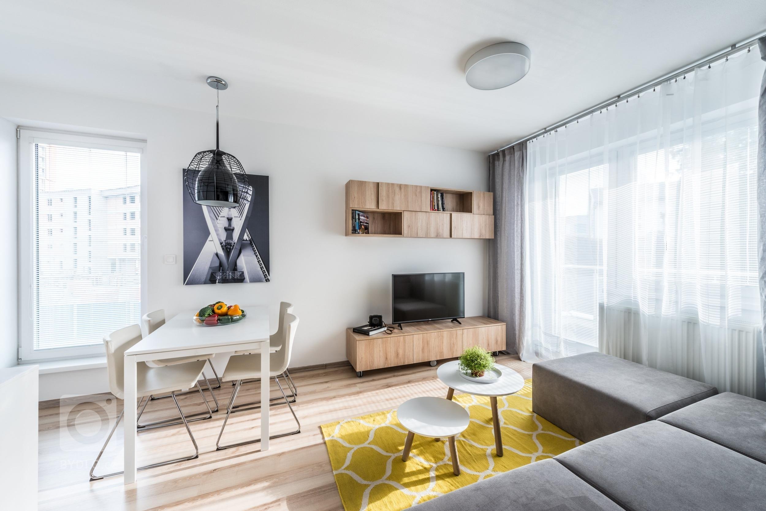 Optimistický interiér malého bytu obsahuje minimum zbytečností, proto působí čistě a prostorně. Velkoplošné fototapety z portfolia majitele zvětšují měřítko…