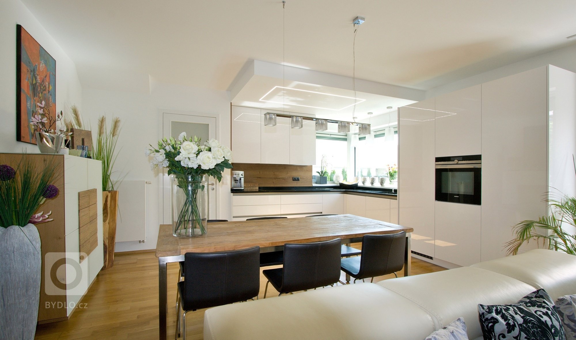 Kuchyň BEECK KÜCHEN, rodinný dům. Provedení lesklý lak s PP hranami Colora. Pracovní deska je Technistone Gobi Black, jako obklad je použito lamino Halifax,…