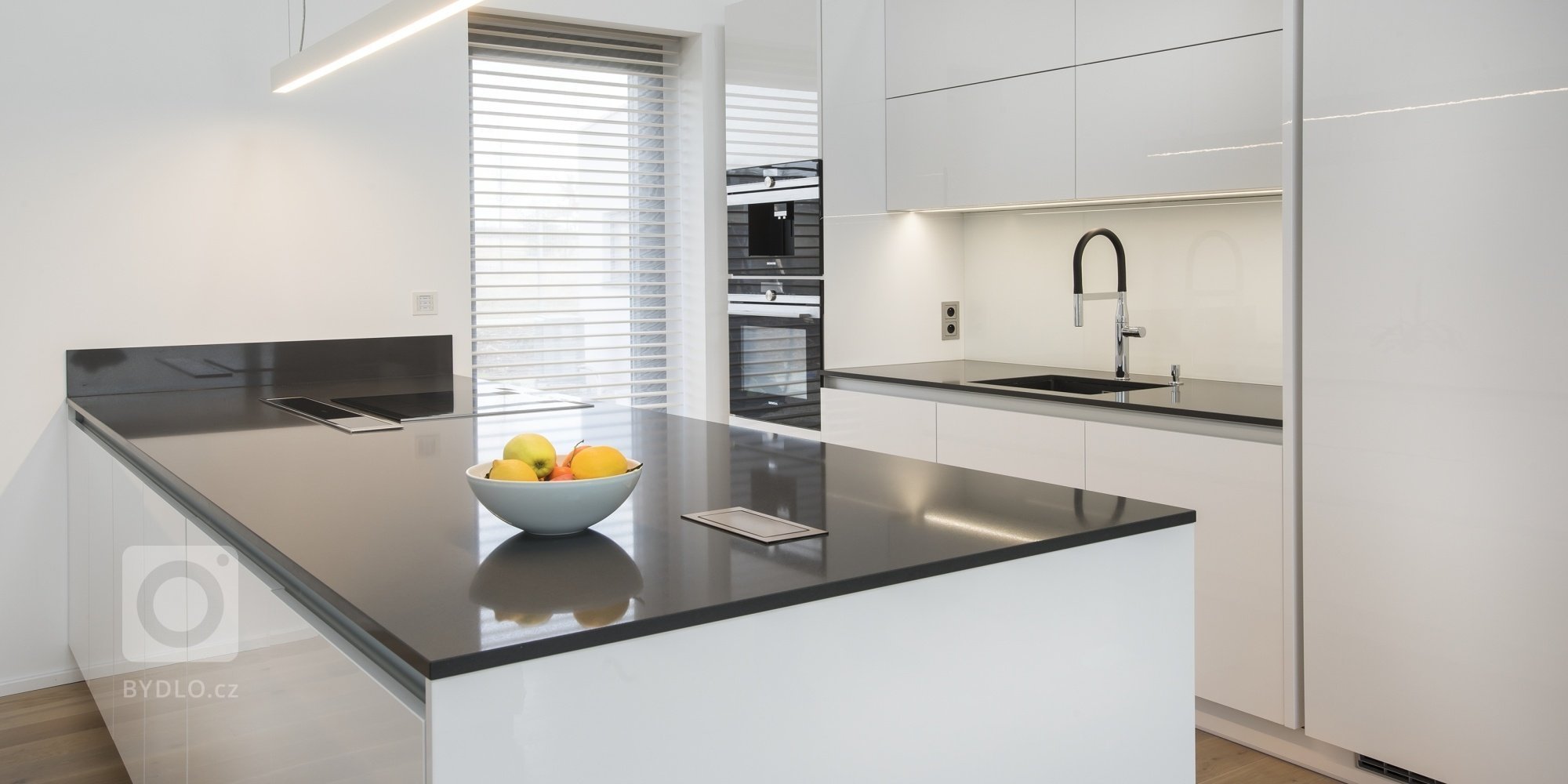 Kuchyň BEECK KÜCHEN, rodinný dům. Provedení - Colora lesk bílá, pracovní deska Technistone Crystal Anthracit. Kuchyň je vybavena spotřebiči Siemens. Stůl a…
