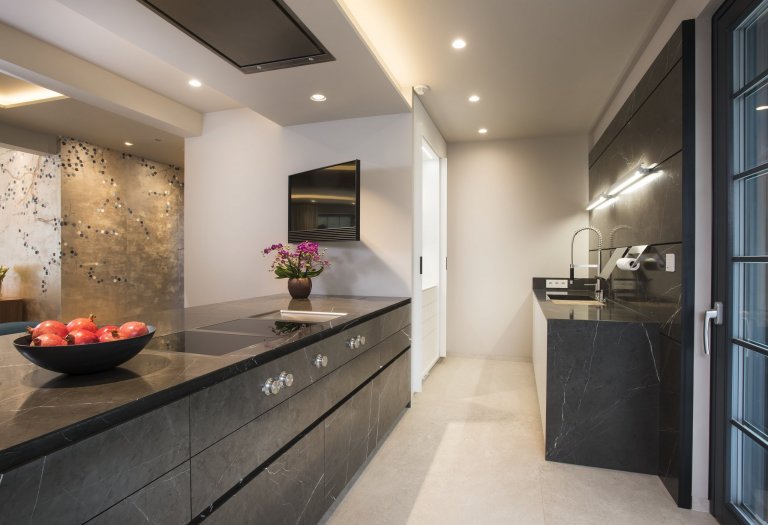 Kuchyň EGGERSMANN UNIQUE, rodinný dům. Provedení je masivní kámen Graphit Brown Leather na ostrůvku v&nbsp;kombinaci s Paso supermatt lotus white a broušeným…