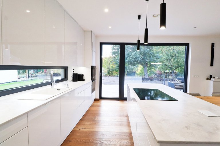 Této kuchyňské lince v&nbsp;Řeži u Prahy bílá prostě sluší.

Lesklý lak v&nbsp;kombinaci s&nbsp;pracovní deskou Technistone působí velmi elegantním a čistým…