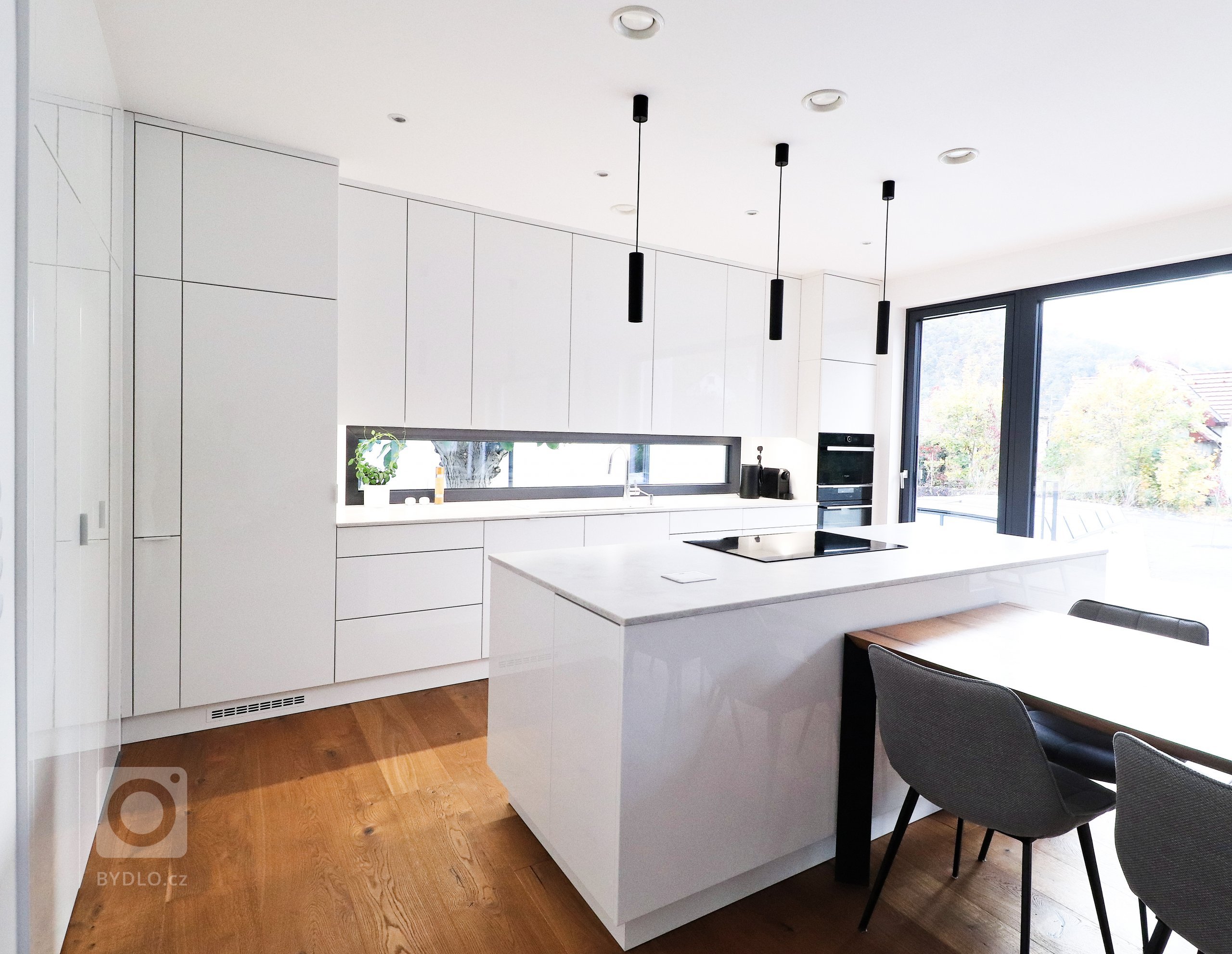 Této kuchyňské lince v&nbsp;Řeži u Prahy bílá prostě sluší.

Lesklý lak v&nbsp;kombinaci s&nbsp;pracovní deskou Technistone působí velmi elegantním a čistým…