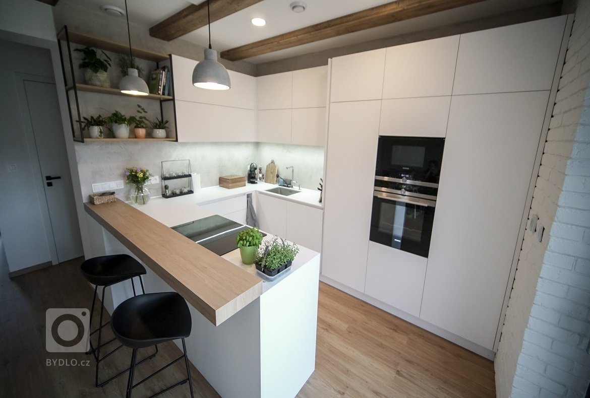 Interiér v minimalistickém stylu, který je laděn do čisté bílé matné doplněné dřevem, trámy a vhodnými doplňky. Interiér je jednoduchý, útulný a svěží.
