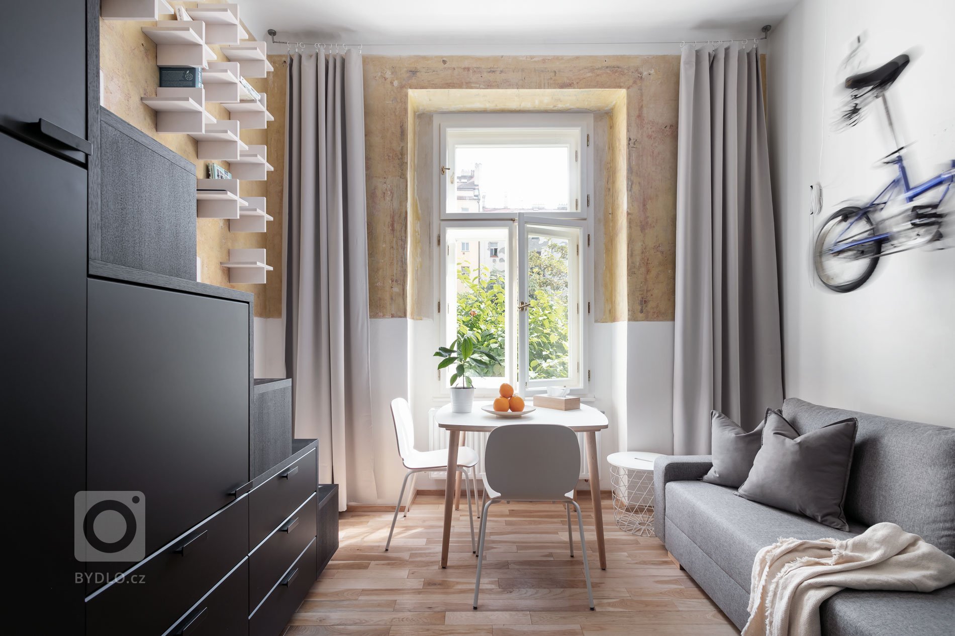 Do vinohradského dvacetimetráku se schoulil černý drak. Po jeho hřbetu je možné vyšplhat do spacího patra. Vnitro obludy skrývá malou koupelnu zářící skrze…