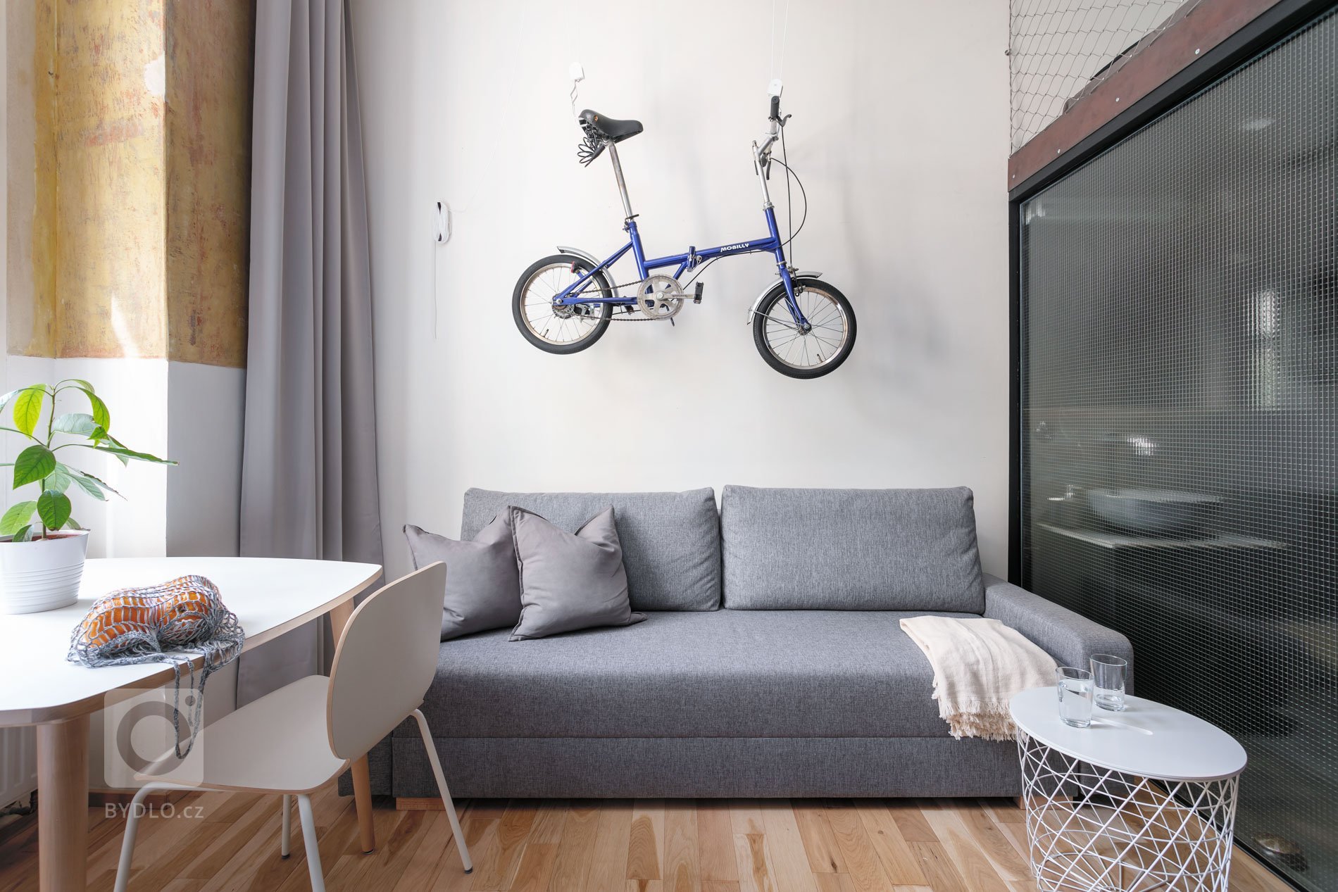 Do vinohradského dvacetimetráku se schoulil černý drak. Po jeho hřbetu je možné vyšplhat do spacího patra. Vnitro obludy skrývá malou koupelnu zářící skrze…