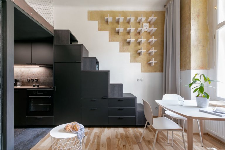 Do vinohradského dvacetimetráku se schoulil černý drak. Po jeho hřbetu je možné vyšplhat do spacího patra. Vnitro obludy skrývá malou koupelnu zářící skrze…