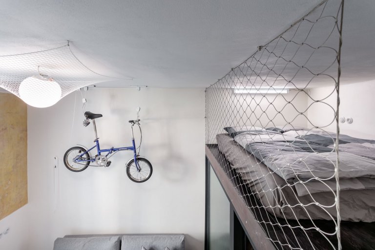 Do vinohradského dvacetimetráku se schoulil černý drak. Po jeho hřbetu je možné vyšplhat do spacího patra. Vnitro obludy skrývá malou koupelnu zářící skrze…