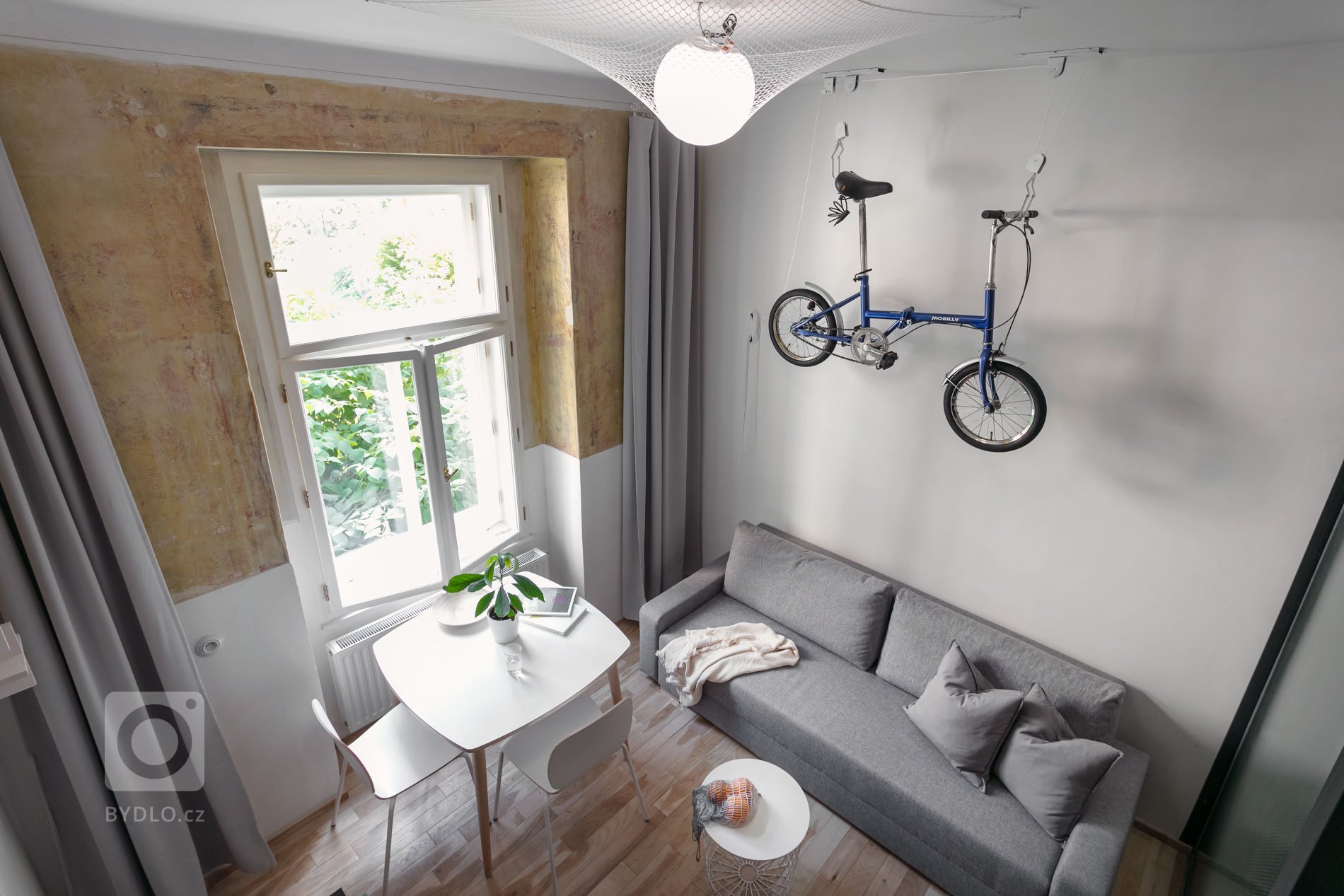 Do vinohradského dvacetimetráku se schoulil černý drak. Po jeho hřbetu je možné vyšplhat do spacího patra. Vnitro obludy skrývá malou koupelnu zářící skrze…