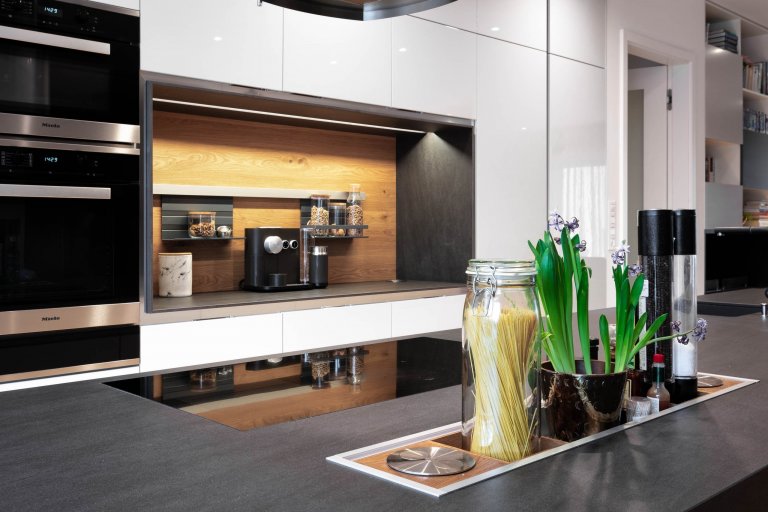 Kuchyň v lesklém laku Grey s velkoryse pojatým odkládacím prostorem, policemi a zástěnou z kartáčovaného dubu. Vysoká sestava, která využívá celou výšku…