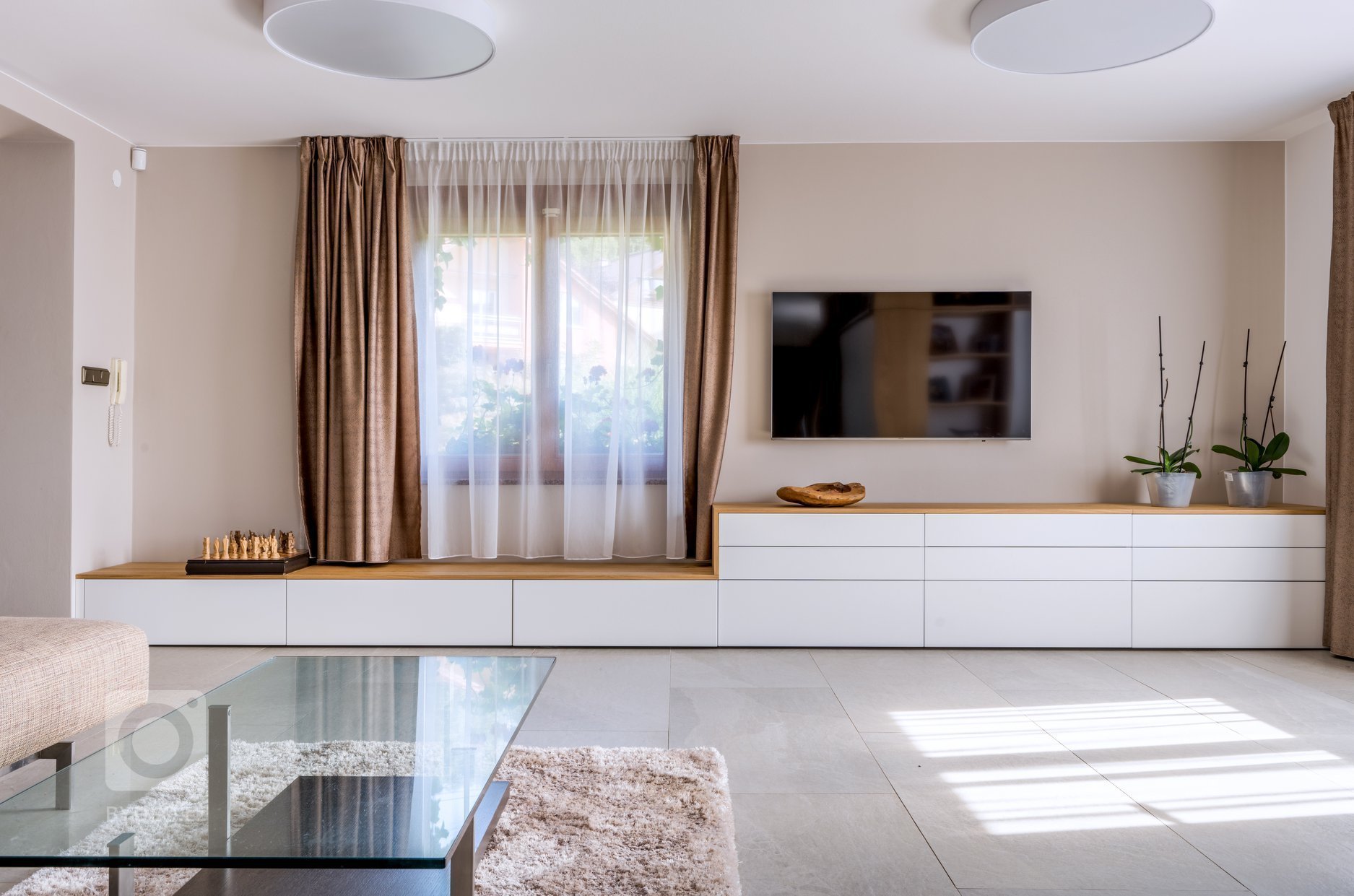 Zásuvková skříň pod TV má lakované bílé dvířka v matu kombinované s dýhou Dub Kartáčovaný.