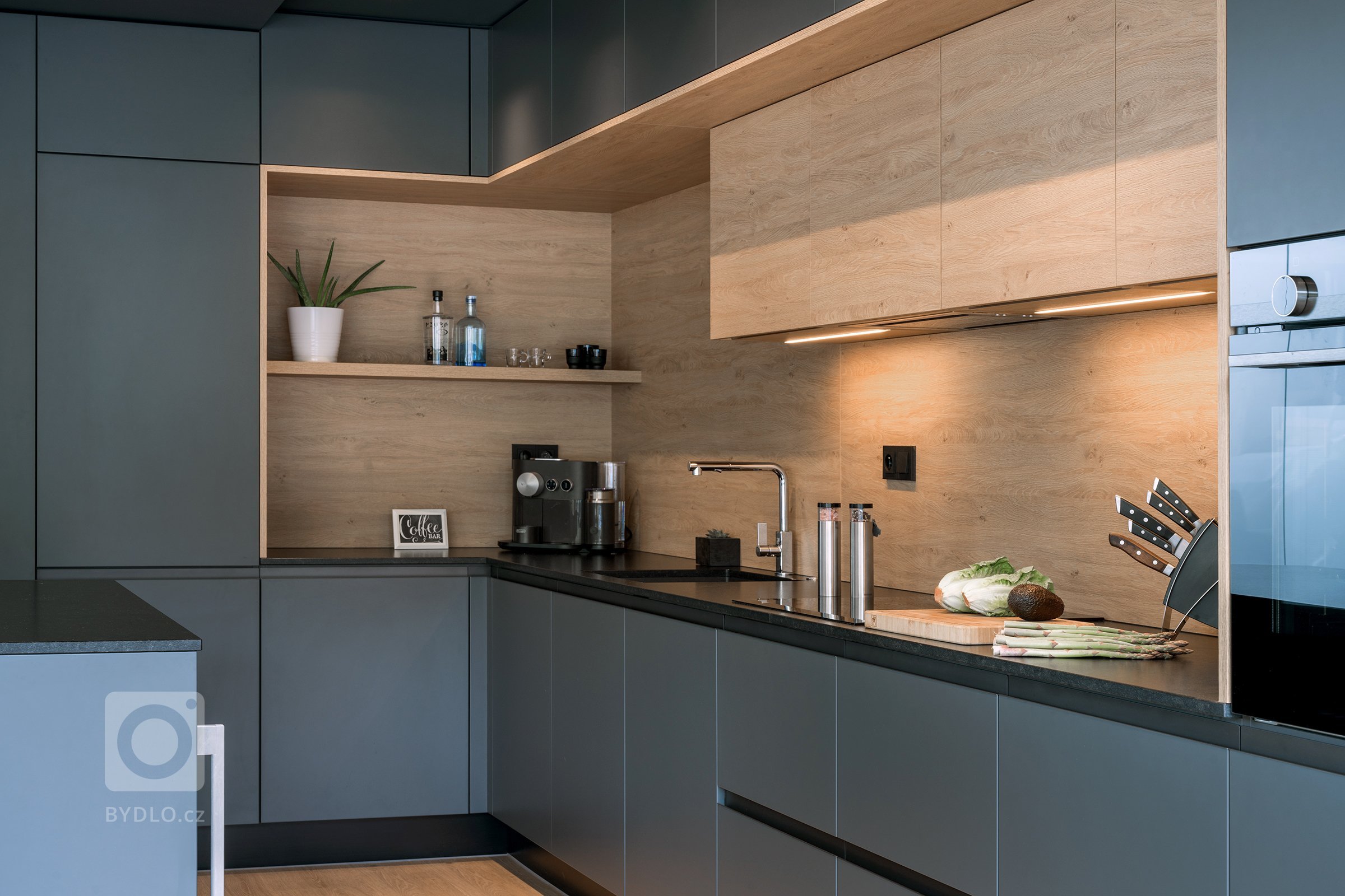 Tmavé barvy oživuje světlé dřevo.