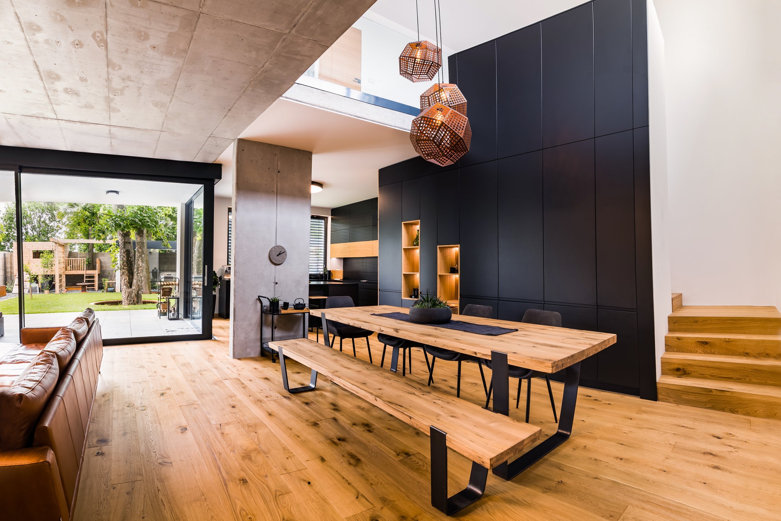 Pocit vyjímečnosti jídelny dodává velký stůl s dřevěnou tabulí a otevřený prostor, který navazuje na obývací místnost.