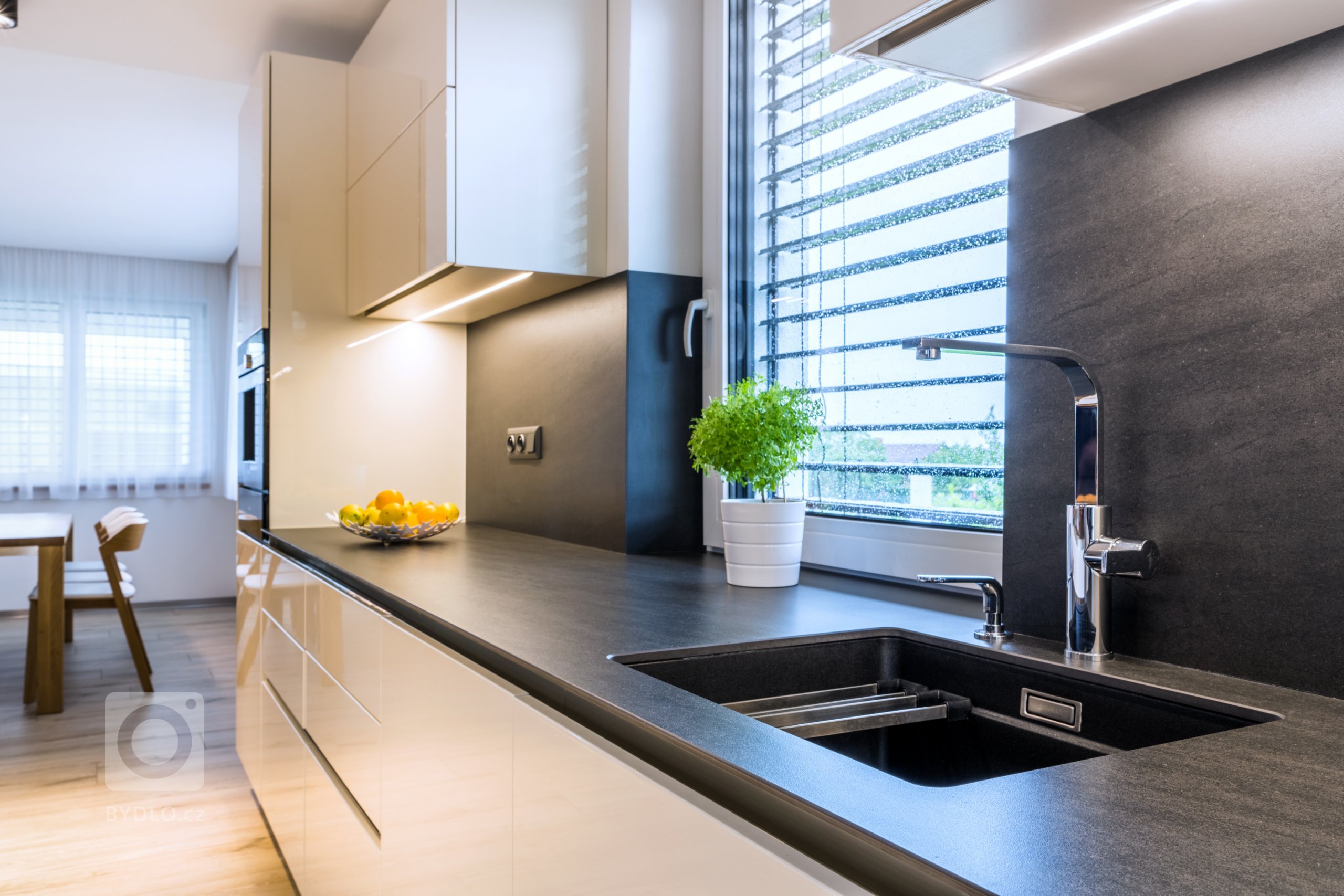 Nechybí ani granitový dřez s dávkovačem saponátu nebo výsuvným odkapávacím roštem. 