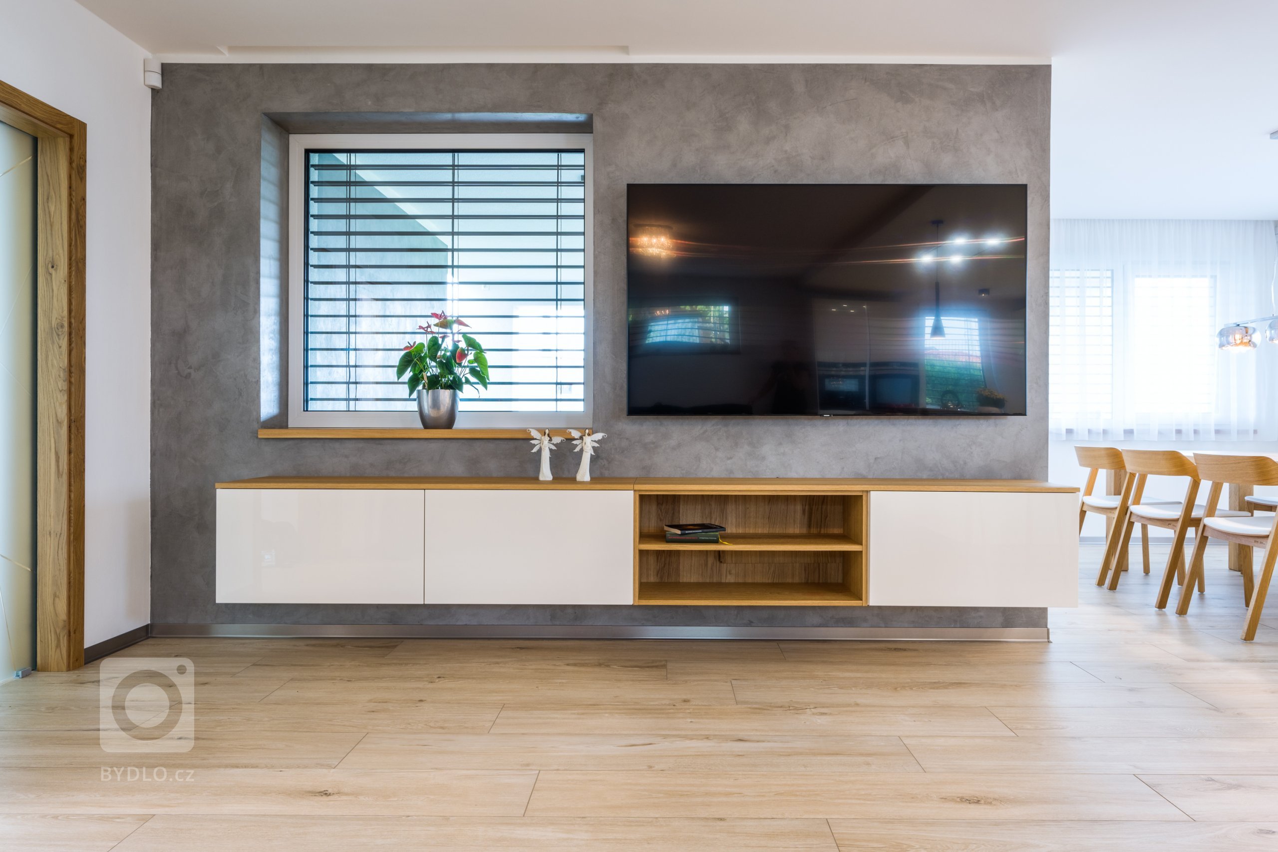 Skříňka pod TV v obývací části ve stejném stylu jako kuchyně.