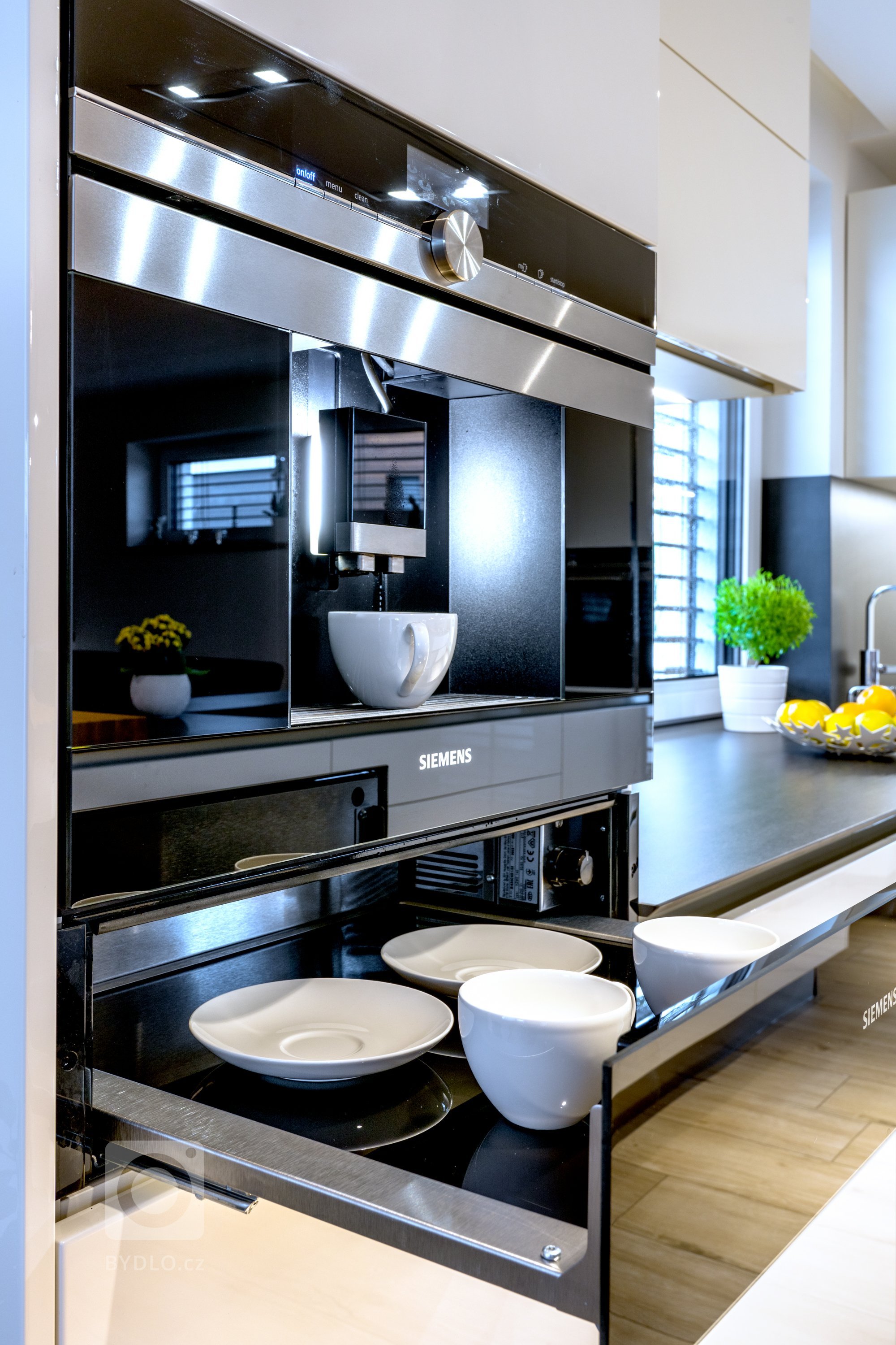 Vestavný kávovar poskytuje nahřívací zásuvku na hrníčky.