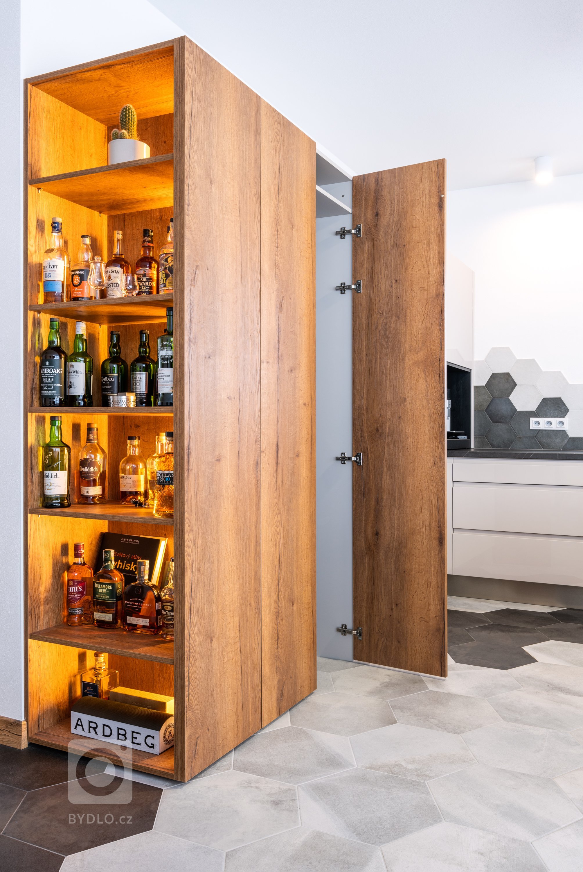 V levém rohu kuchyně je umístěna jedna z libůstek sestavy, na kterou majitelé nedají dopustit, a kterou jim chválí všichni hosté. Jde o skrytou místnost za dřevěnou stěnou s whiskotékou - uvnitř se nalézá druhá lednice, policový systém na trvanlivé potraviny a nápoje. 