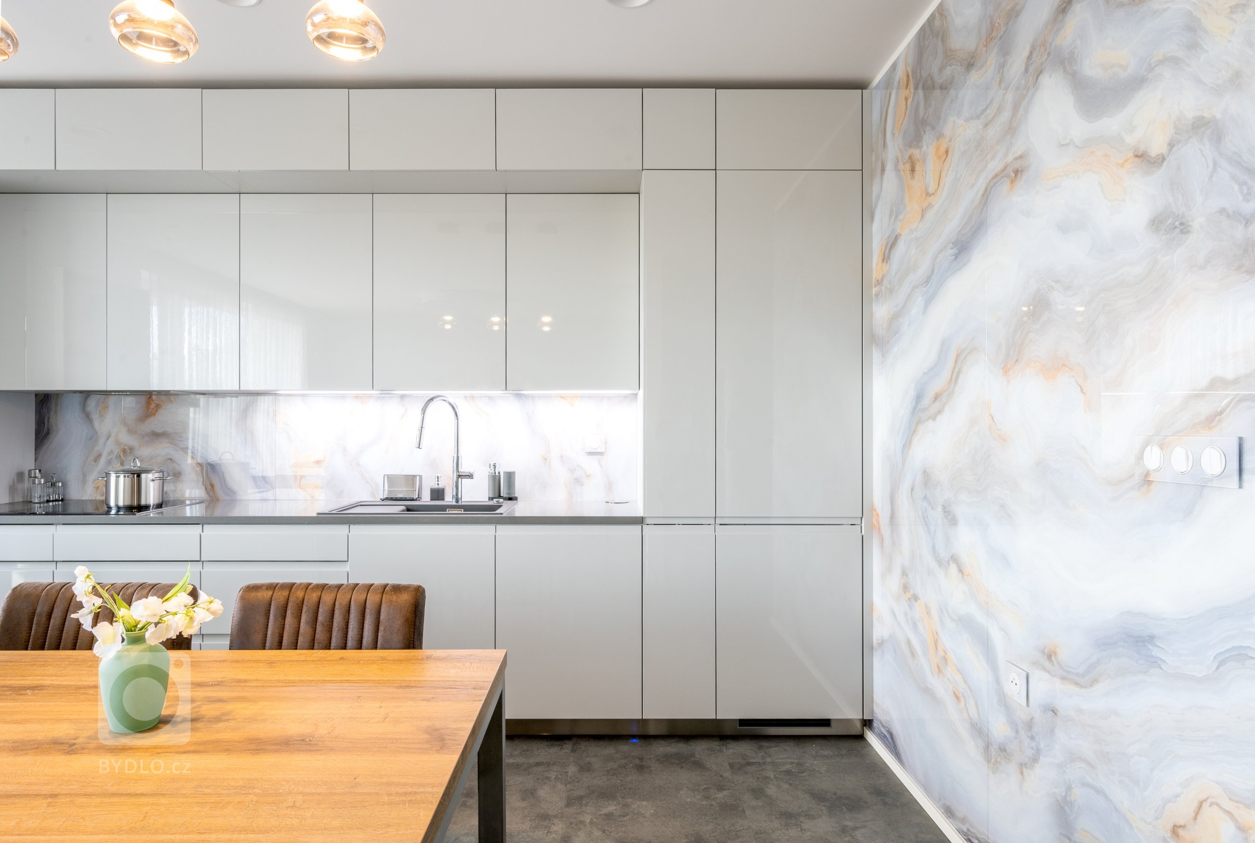 Nejvýraznějšími designovými prvky této kuchyně jsou obkladové zástěny ze skla Onyx. Tvoří boční obložení nad mycí a varnou zónou a pokrývají i celou jednu stěnu místnosti.