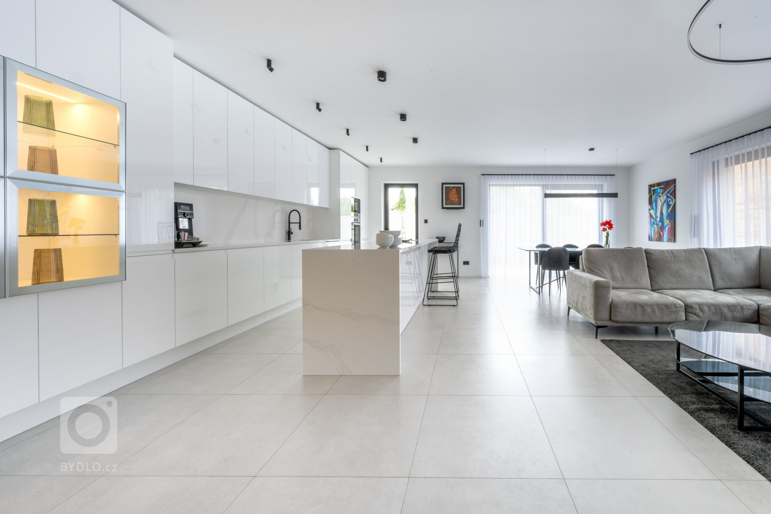 Sestava v hladkém, čistém designu Pure tvoří celou jednu stranu místnosti.
Geometricky vyrovnaná a přesto členitá, designová a zároveň praktická, nabízí ideální podmínky pro kulinářské aktivity i pro rodinný život. Bílé dvířka skříněk jsou lakované v lesku White, který se snadno udržuje a odolává stopám času i rodinných příslušníků. 
