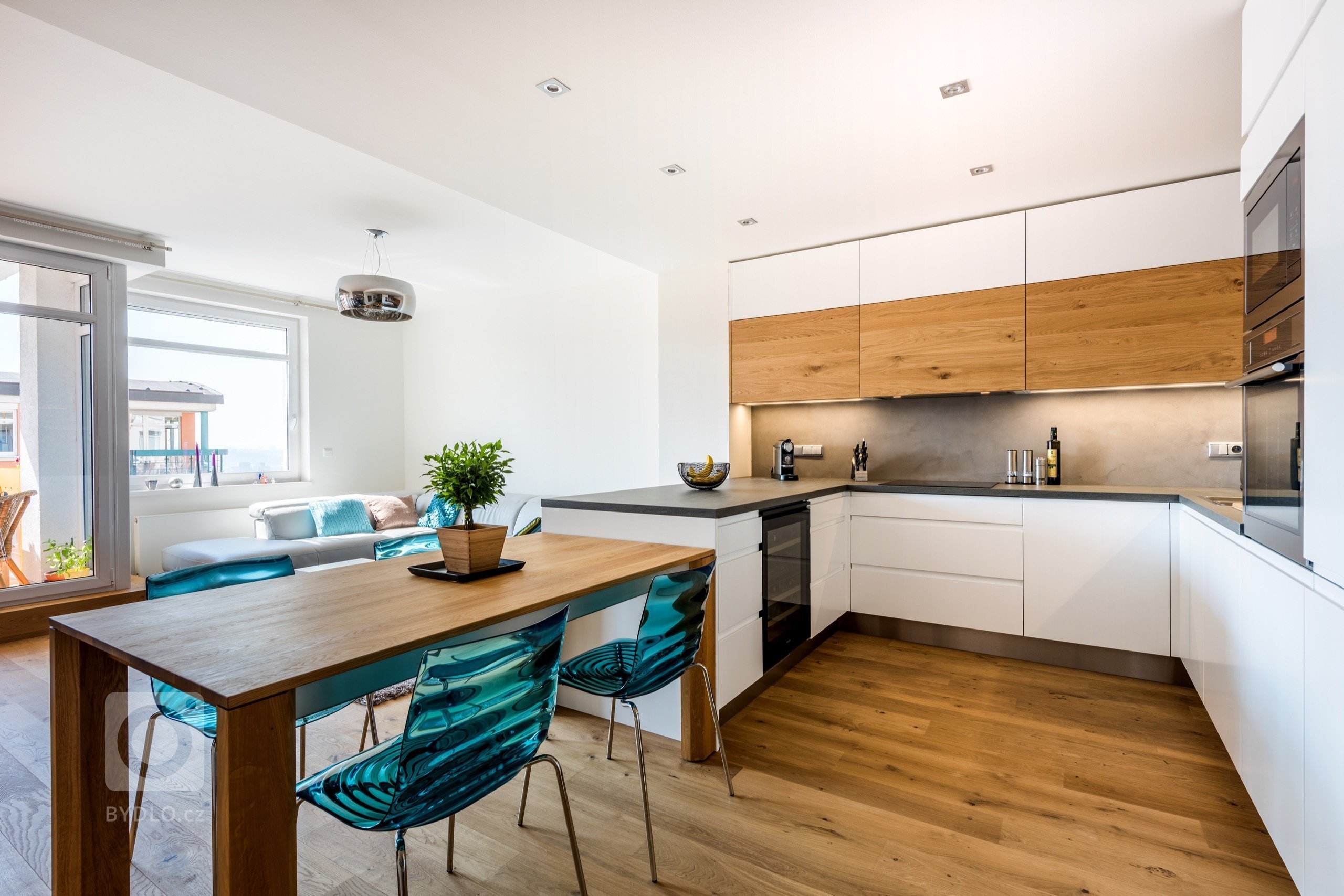 Čistokrevná kuchyně, ve které nic nechybí ani nic nepřebývá. Sofistikované plochy skříní v bílém matu jemně vykreslují prostor, zatímco dubové dřevo s…