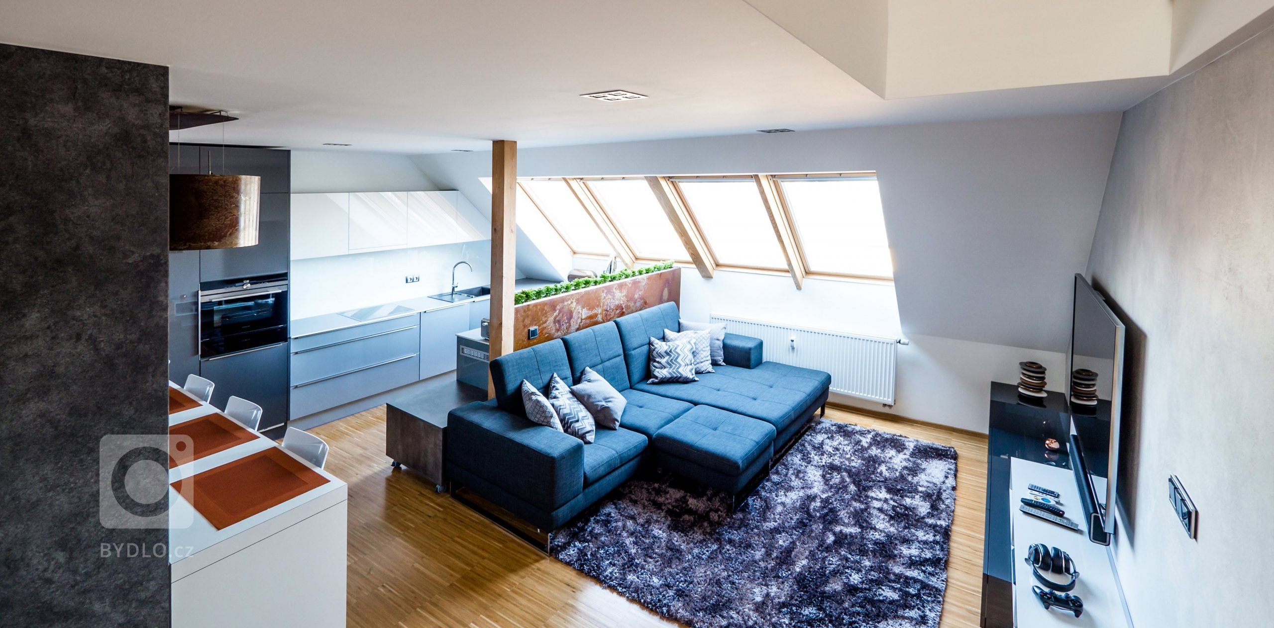 V bytě zůstaly původní podlahy, dveře a okna ve výrazném odstínu dubového dřeva, které by bylo velice nákladné měnit...