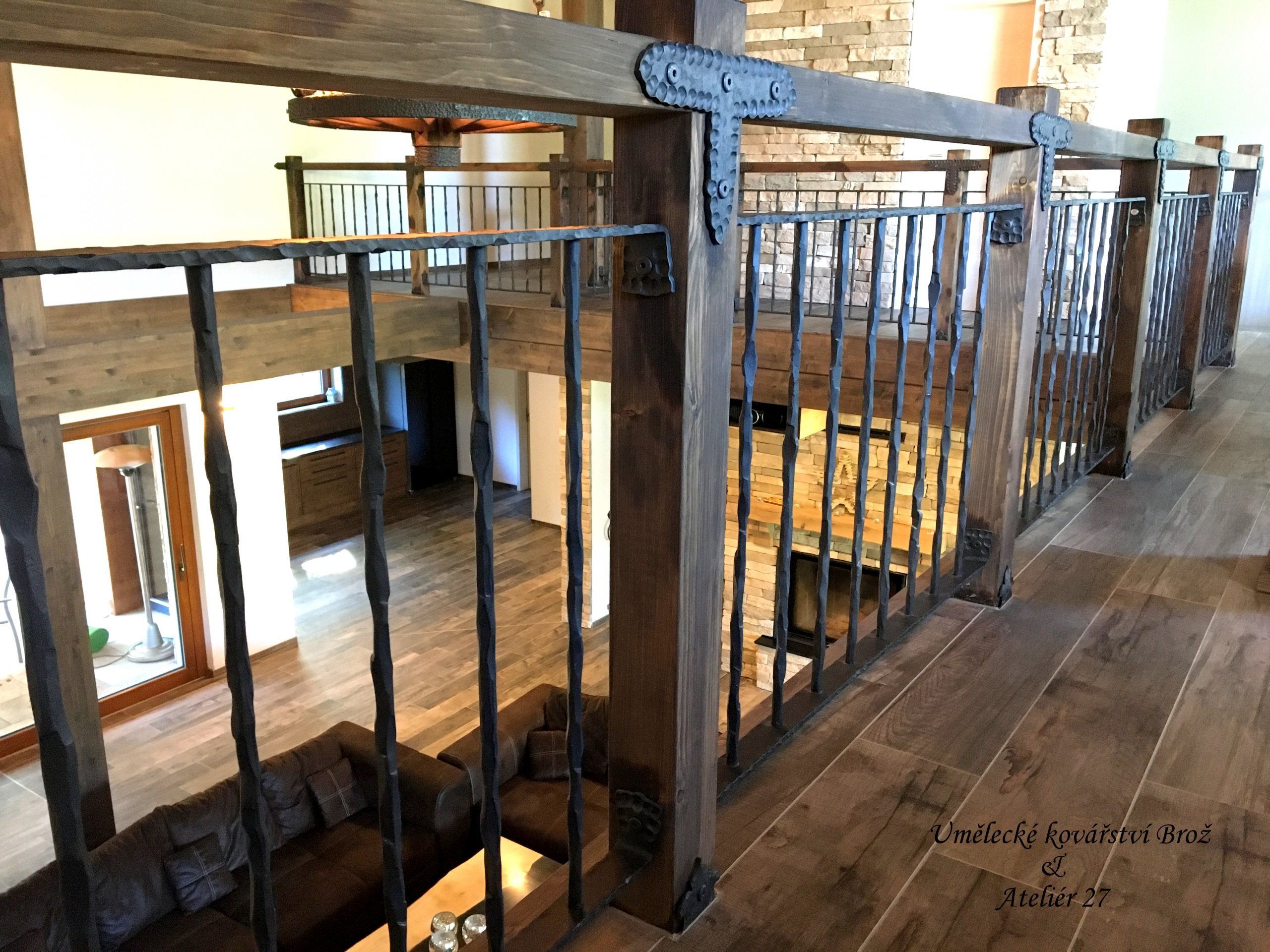 Kované zábradlí v kombinaci s opalovaným, kartáčovaným&nbsp;&nbsp;dřevem. Svislá kulatina kompletně zdobena údery kladiva. Zábradlí zhotoveno do horského…