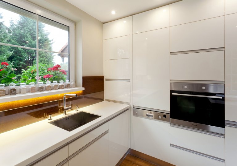 Představujeme vám malebnou kuchyň, která kombinuje moderní bílé povrchy s&nbsp;teplými tóny dubového dřeva. Přestože místnost není zrovna prostorná, i tak se…