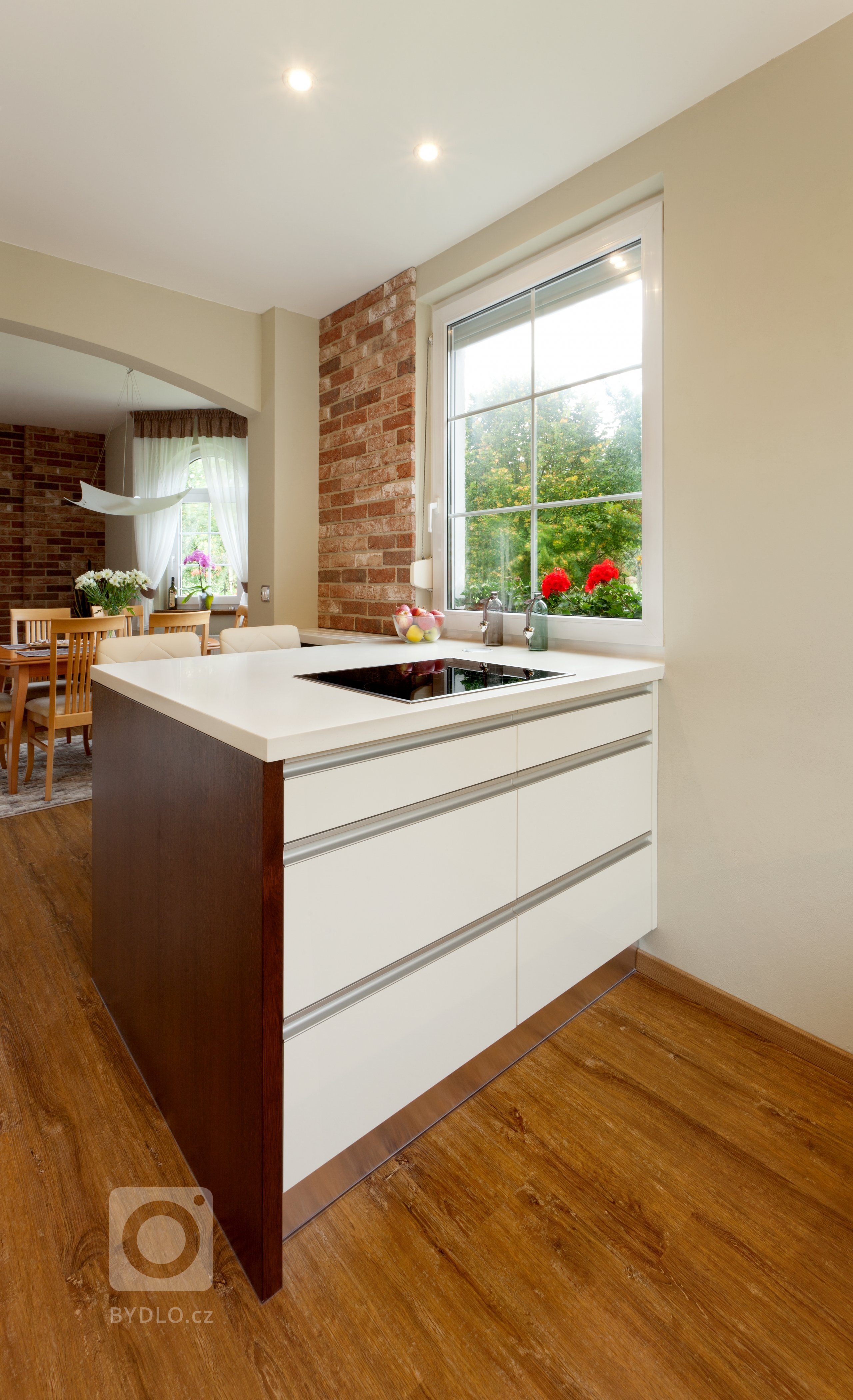 Představujeme vám malebnou kuchyň, která kombinuje moderní bílé povrchy s&nbsp;teplými tóny dubového dřeva. Přestože místnost není zrovna prostorná, i tak se…