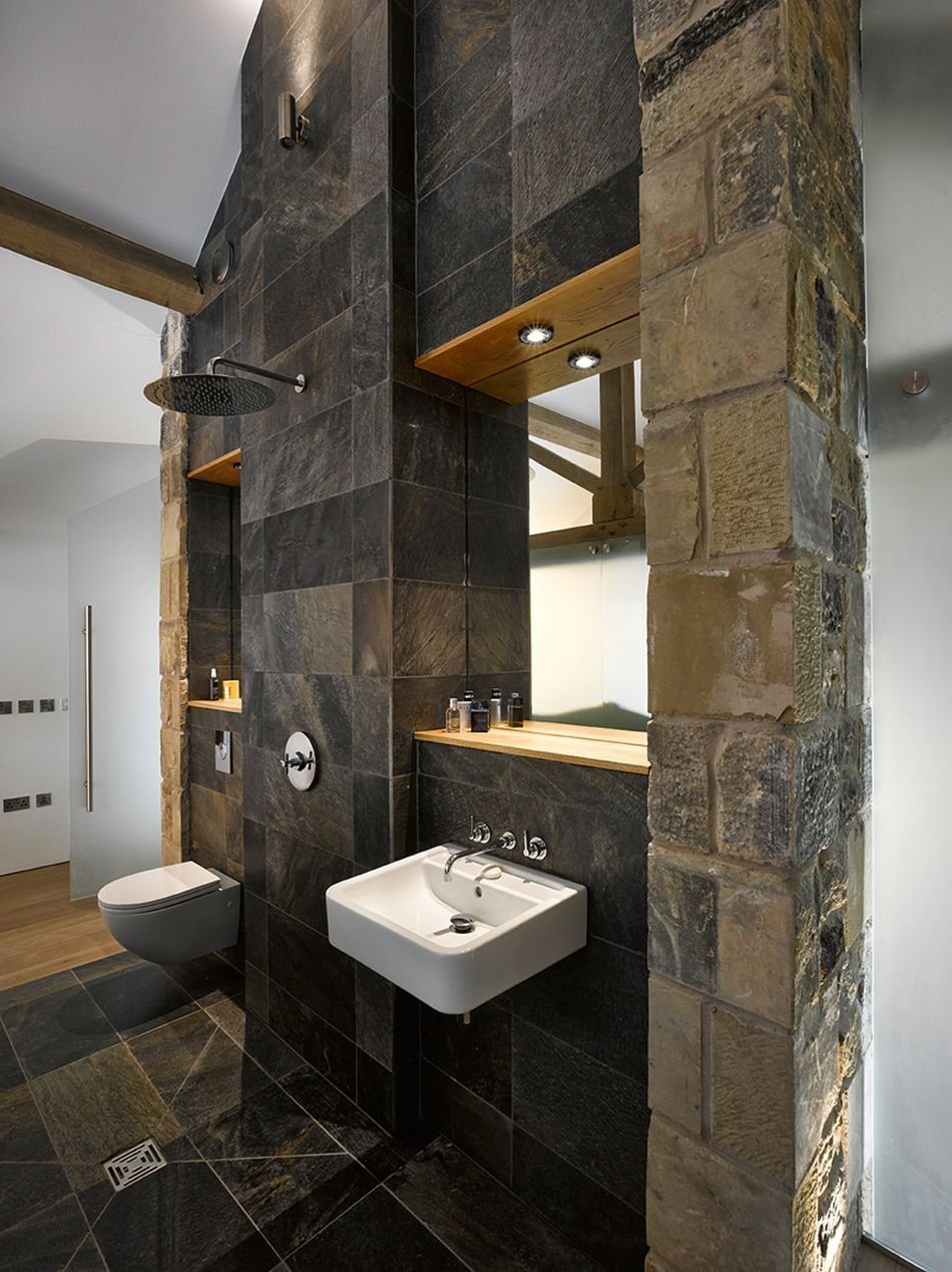 Otevřený sprchový "kout" je moderní, kamenný obklad navazuje na původní účel budovy. 
