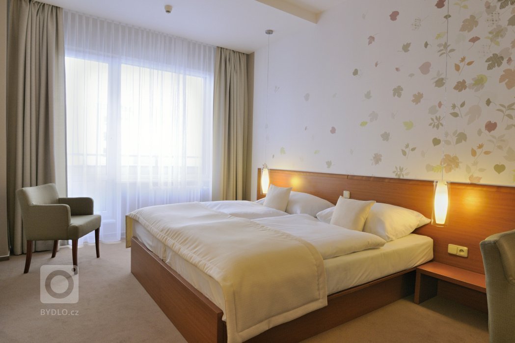 Proměna hotelového pokoje s částečným využitím stávajícího mobiliáře. Barevné ladění&nbsp;v podzimních tónech s odpovídajícím dekorem obrazové tapety přináší…