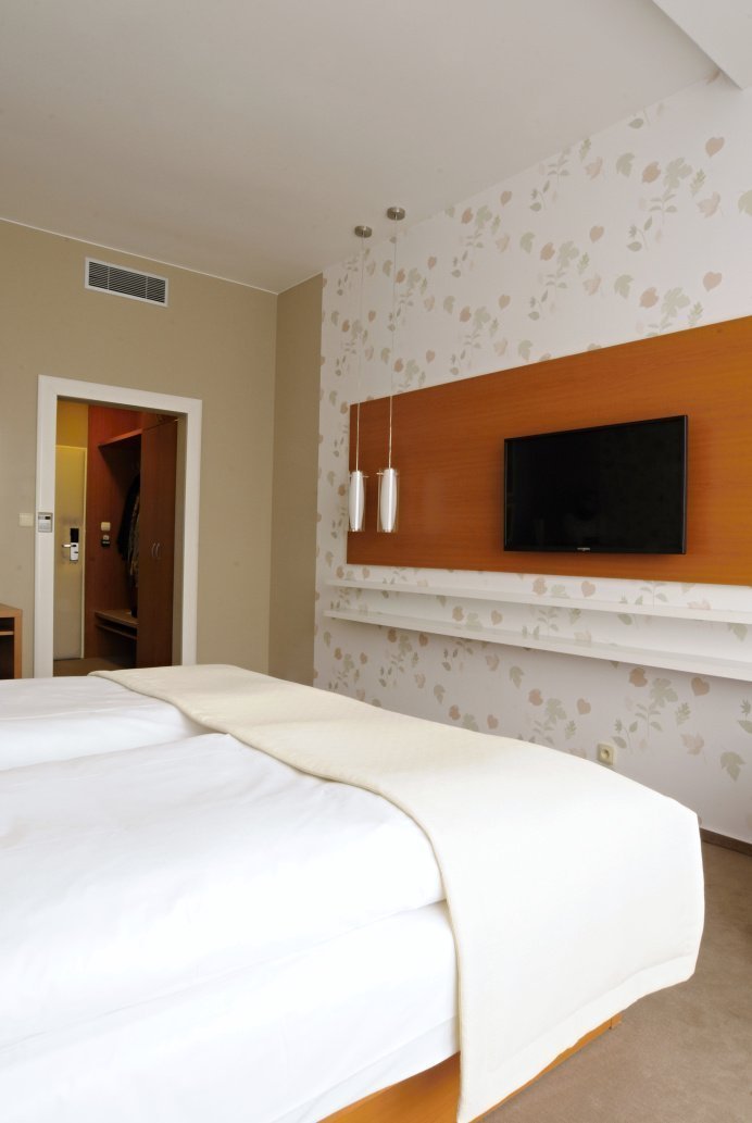 Proměna hotelového pokoje s částečným využitím stávajícího mobiliáře. Barevné ladění&nbsp;v podzimních tónech s odpovídajícím dekorem obrazové tapety přináší…