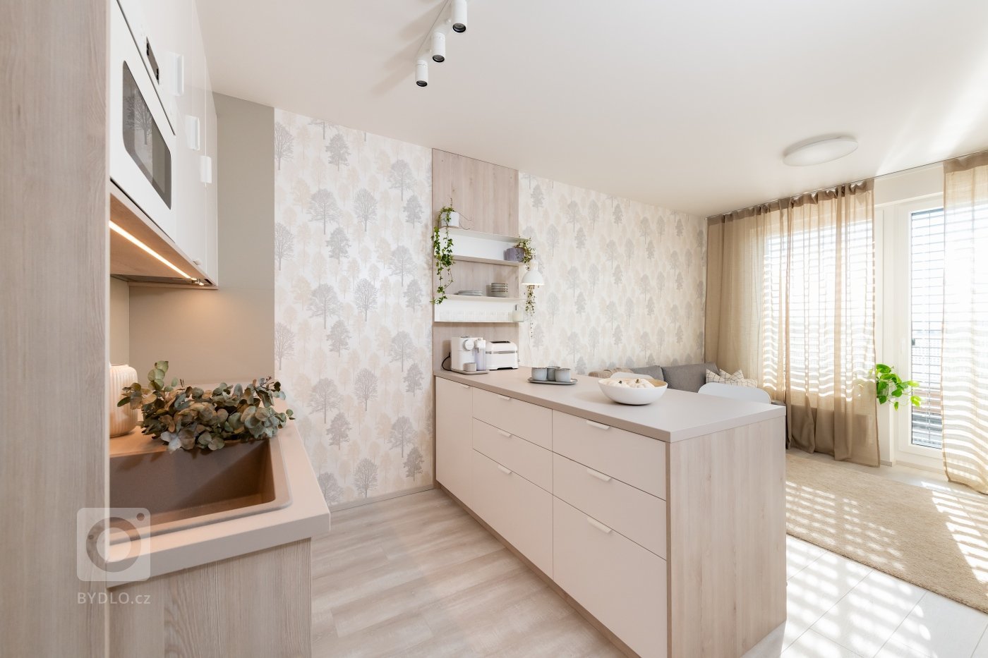 Útulná garsonka v novostavbě na severu Prahy.
Kuchyňská část: Minimalistická kuchyň s vestavěnou mikrovlnnou troubou, světlými skříňkami a dřevěnými akcenty.…