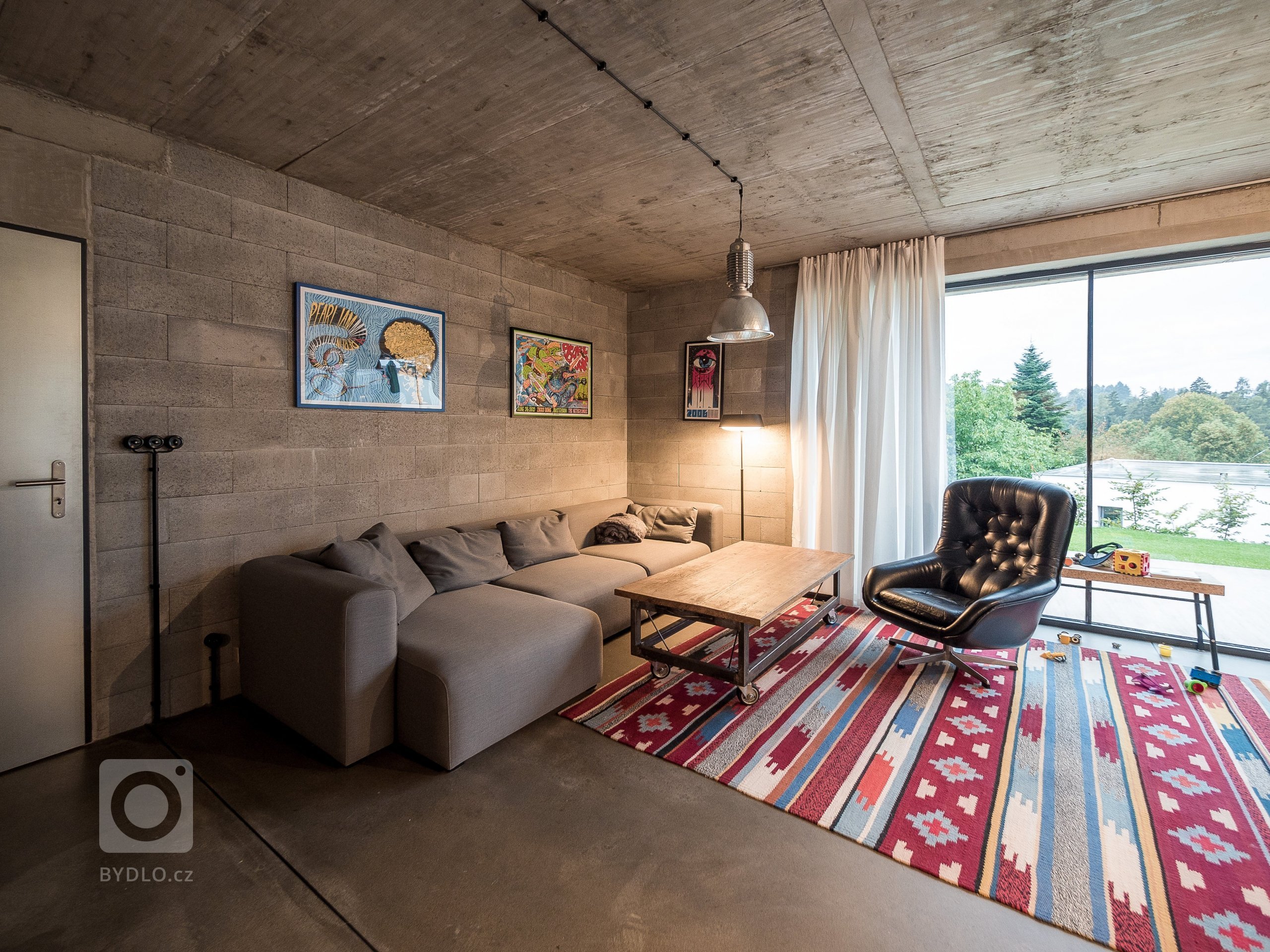 Obytný prostor ZEN HOME s velkým prosklením, které kotrastuje k masivním betonovým konstrukcím.