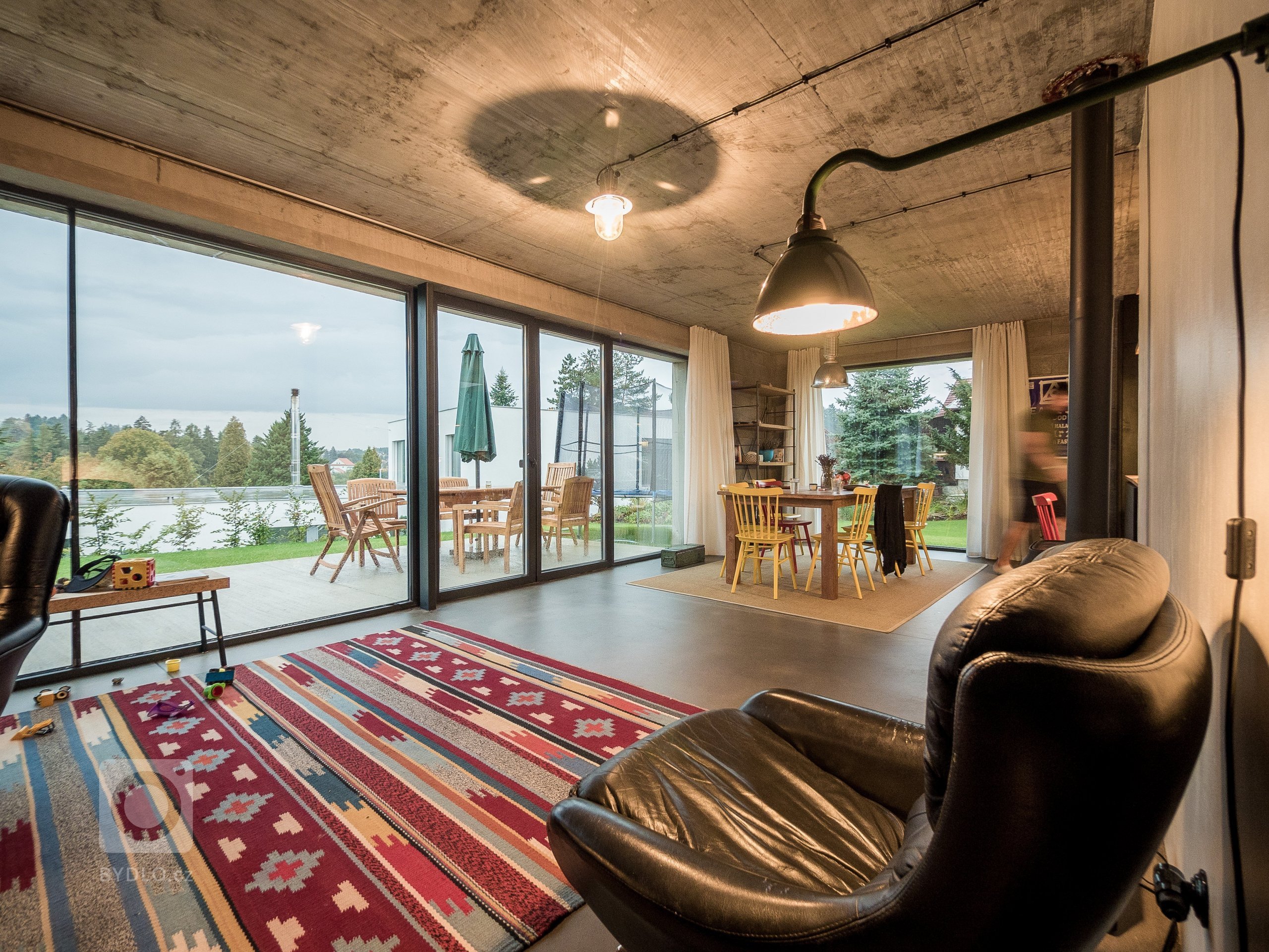 Obytný prostor ZEN HOME s velkým prosklením, které kotrastuje k masivním betonovým konstrukcím.